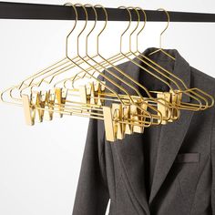 a suit and tie hangers are hanging on a clothes rack in front of a white background