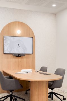 a conference table with chairs around it and a flat screen tv mounted on the wall