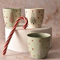 three cups with candy canes sitting on top of each other