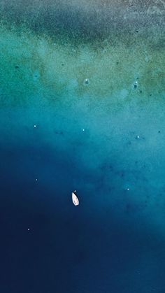 an aerial view of a body of water with a boat in it