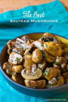 the best sauteed mushrooms in a bowl on a blue cloth with a spoon