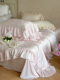 a bed with pink ruffled bedspread and pillows