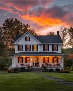 a large white house sitting on top of a lush green field under a cloudy sky