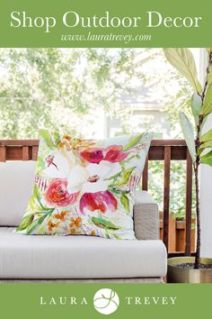 a white couch sitting on top of a wooden floor next to a potted plant