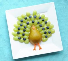 a plate with grapes on it and a turkey made out of grapes in the middle