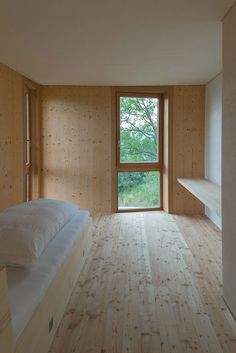 an empty bedroom with wooden walls and flooring