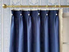 the curtain is closed and ready to be hung in front of a window with blue wallpaper