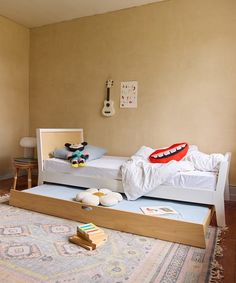 a child's bedroom with a bed and toys on the floor