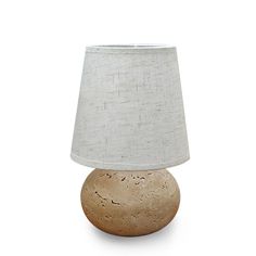 a lamp that is sitting on top of a white surface with a light shade over it