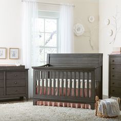 a baby crib in a room with two dressers