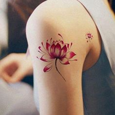 a woman with a tattoo on her arm and shoulder, has a pink flower in the center