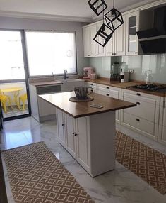 a kitchen with an island in the middle and lots of cupboards on both sides