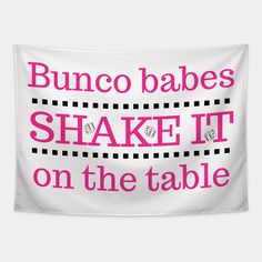 a white banner with pink lettering that says, bunco babes shake it on the table