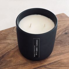 a black candle sitting on top of a wooden table