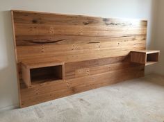 a wooden headboard with two cubby holes in the middle and shelves on each side