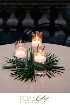 three lit candles sit on top of a table