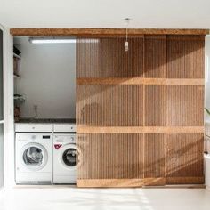 a washer and dryer in a room with wooden slats on the wall