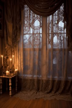 a window with sheer curtains and candles in front of it, on a wooden floor