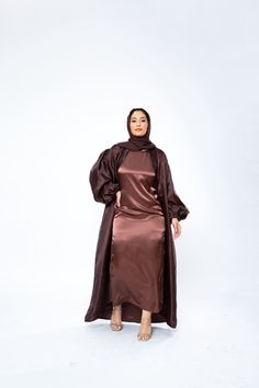 The Organza Abaya is statement outfit for any event. It's super lightweight yet so simple with the prettiest sheen. Complete the look with our matching long sleeve satin slip dress and a pair of strappy heels for a luxe finish or make it into a more casual look. *Please note that the color displayed in the picture might be slightly different due to the color resolution and lighting. Fabric Description & Care: Balloon Sleeves with elastic cuff Double Lined Material: Silk/Organza Dry Clean for bes Evening Satin Maxi Abaya, Evening Satin Maxi-length Abaya, Elegant Long Sleeve Brown Abaya, Elegant Silk Abaya For Party, Elegant Satin Maxi Abaya, Silk Long Abaya For Party, Silk Party Abaya, Elegant Satin Abaya For Party, Satin Evening Abaya For Eid