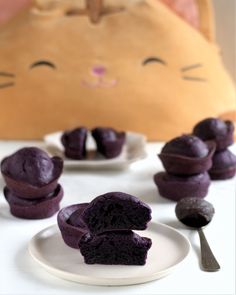 purple cupcakes on a white plate with a cat in the background