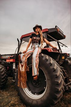 a woman sitting on the back of a tractor