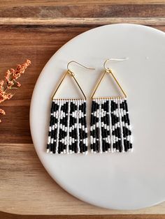 These earrings have a modern and lively feel with their matte white and black geometric design. Beaded fringe hangs from a beautiful gold plated triangular form with 14K gold plated hypoallergenic ear wires. **Each of my earrings are delicately handwoven bead by bead. I absolutely love making these and want you to know that each piece is made with patience and care from start to finish! These earrings are made with size 11/0 Delica Japanese Miyuki seed beads. I use strong nylon thread to ensure Minimalist White Beaded Dangle Earrings, Handmade White Triangle Beaded Earrings, White Bohemian Geometric Earrings, White Geometric Bohemian Earrings, Bohemian White Geometric Earrings, Brick Stitch Earrings, Beaded Earrings Patterns, Bead Embroidery Jewelry, Beaded Crafts