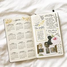 an open planner book on top of a bed with pictures and calendars in it