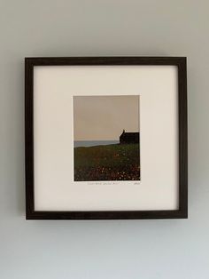 a black and white photo hanging on the wall next to a vase with flowers in it