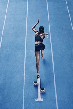 a woman is running on a blue track