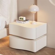 a night stand with two drawers and a clock on it in the corner of a room