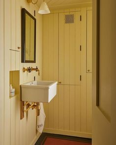 a white sink sitting under a bathroom mirror next to a wall mounted faucet