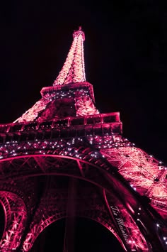 the eiffel tower lit up at night with lights on it's sides