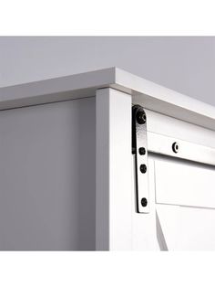 an image of a white cabinet door with black knobs