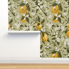 a wallpaper with lemons and white flowers on a green background in an empty room