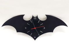 a clock made to look like a bat hangs on the wall in front of a white background