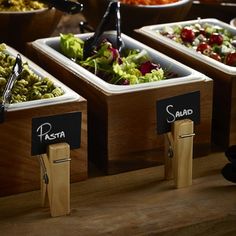 there are many different types of salads in the trays on the table together