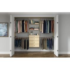 an open closet with clothes hanging on the wall and drawers in front of it,