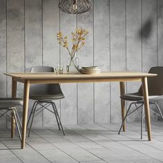 a dining table with chairs and plates on it in front of a wall that has wood paneling