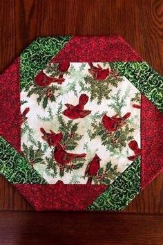 two red and green placemats sitting on top of a wooden table