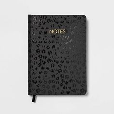 a notebook with the words notes written in gold foil on top of black leopard print