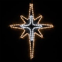 a lighted star ornament in the shape of a snowflake on a black background