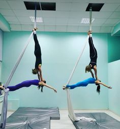 two women doing acrobatic tricks in an empty room