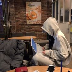 a person sitting at a table with a laptop