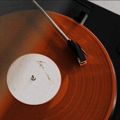 an old record player with its turntable pulled up to the side by a cable