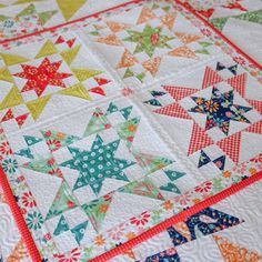 a quilted table topper with colorful stars on it