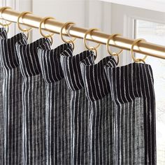 black and white striped curtains hanging from a gold rod