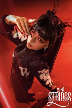 a woman with black hair and piercings posing for a magazine cover photo in front of a red background