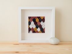 a white frame with a red, yellow and black pattern on it next to a ball