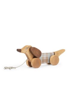 a wooden toy dachshund sitting on top of a white floor next to a string