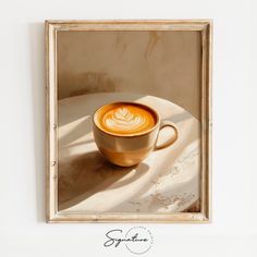 a cup of coffee sitting on top of a white table next to a framed photo